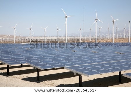 A Genuine Energy Farm in the Hot Arid Desert of Palm Springs California features Solar Panels and Wind Turbines to Harness the Power of Nature to generate free green energy to sell to the masses