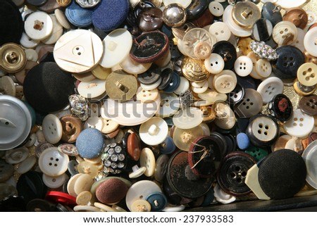 Piles and Piles of beautiful and colorful used buttons of various articles of clothing and save in a box for future sewing or art projects. Buttons are an important part of the sewing process