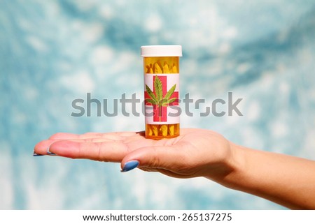 A medical marijuana prescription with a label held by an unknown woman with blue finger nails against a blue sky canvas background