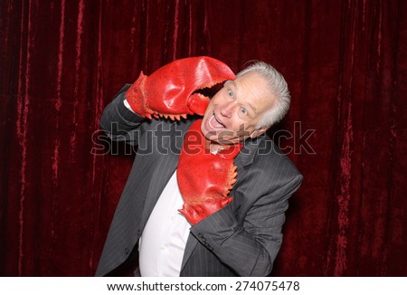 A Business Man is attacked by his own Lobster Claw Hands while in a Photo Booth.