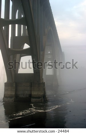 fog moves in and around a bridge in oregon
