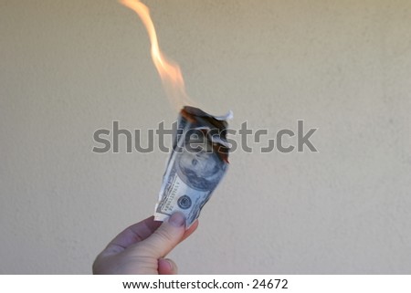 Money To Burn!\
\
A hand holding a one hundred dollar bill and a twenty dollar bill on fire