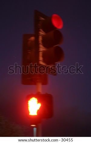 a red traffic light also has a no crossing symbol attached and activated at the same time in this special time laps (bulb exposure) image at night