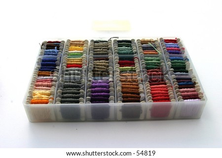 many colors of embroidery thread lined up in its  box on a white background