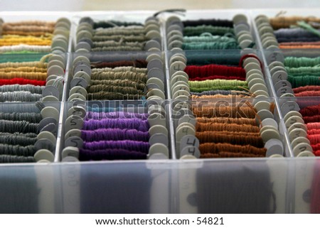many colors of embrordary thread lined up in its  box on a white background