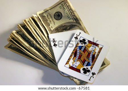 Black Jack hand laying on top of a pile of cash in $100.00 bills on a white background