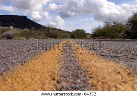 Double yellow line of a two lane road constricts into the vanishing point  in Arizona