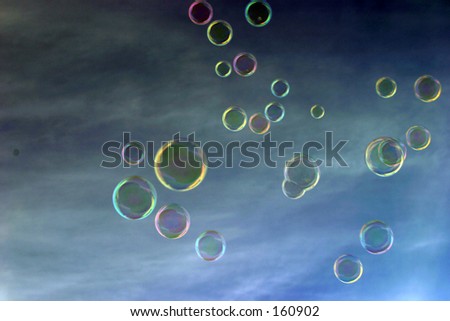 soap bubbles float freely through the air with a blue sky