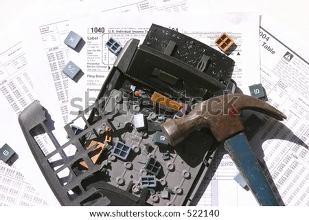 计算器捣毁了与锤子在它旁边在堆税表和文书工