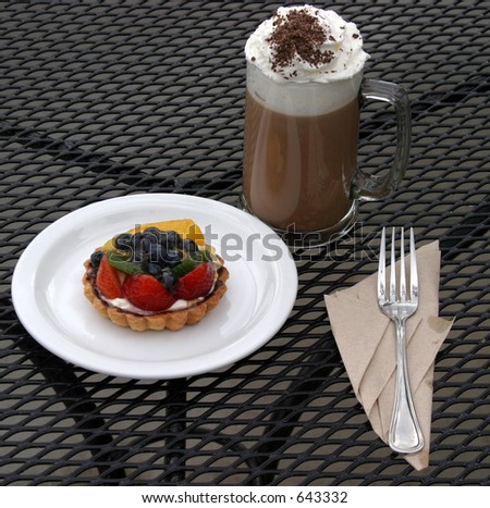 Mocha Cappuccino with whipped cream chocolate powder and a fruit tart