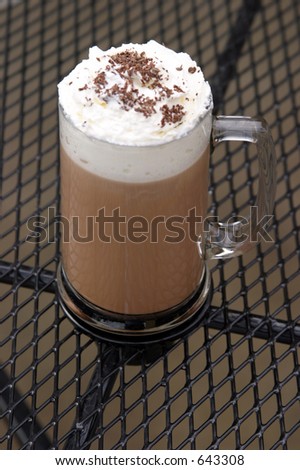 Mocha Cappuccino with whipped cream chocolate powder on mesh table outside