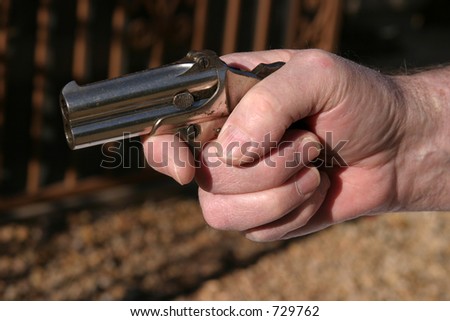 an antique 2 shot .45 cal derringer hand gun easly fits in the palm of a mans hand