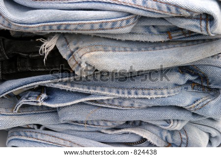 a pile of worn blue jeans
