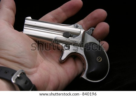 Circa 1889, Model 95, Type II Model 3 Double Derringer, in the palm of a mans hand showing the small size of the gun