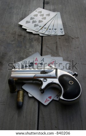 Circa 1889, Model 95, Type II Model 3 Double Derringer, on an antique wooden table with aces and eights aka a 
