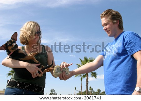 A young man gives a young woman a hand full of cash for unknown possiable transactions