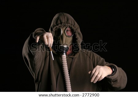 anti-smoking concept a man in a gas mask holds a cigarette with disgust