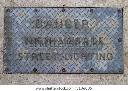 High Voltage street sign bolted to the sidewalk