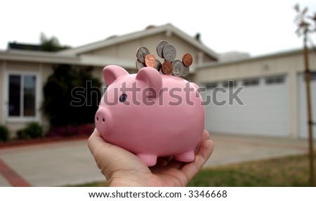 Saving for a home concept pink piggy bank in front of a house