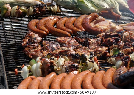 various types of meats being barbecued at an outdoor art show