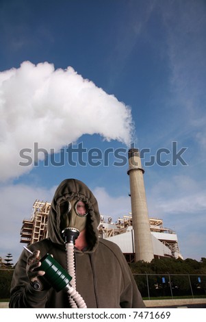 a man in a Gas Mask tries to smoke a cigarette infront of an industrial smoke stack representing Global Warming and Anti-Smoking Message at the same time