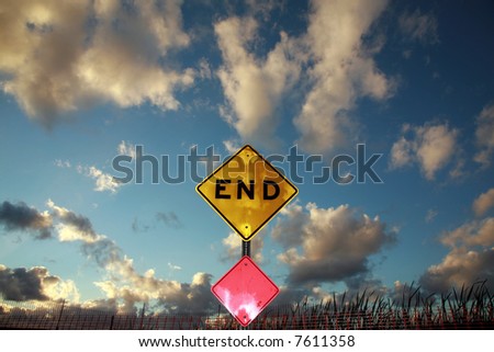 an End sign sits at the end of a road against a Blue Sky with Amazing fluffy clouds