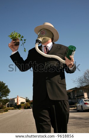 an environmentally friendly business man in a nice suit, and a Gasmask holds a green plant to save the earth from Global Warming