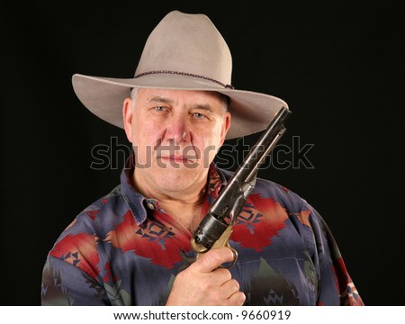 A cowboy poses for his portrait with his Colt Navy 44 caliber black powder revolver