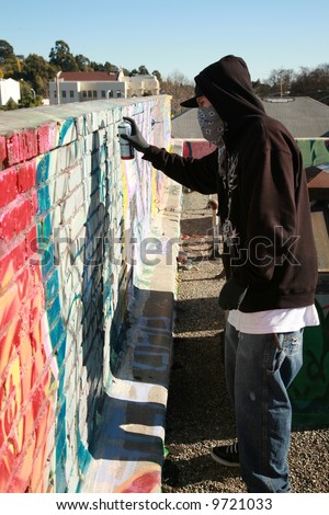 an unidentifiable person spray paints graffitti on \