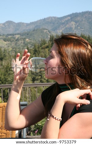a wine connoisseur sniffs the delicate boquet of her glass of wine before tasting it to be assured of the quality and vintage