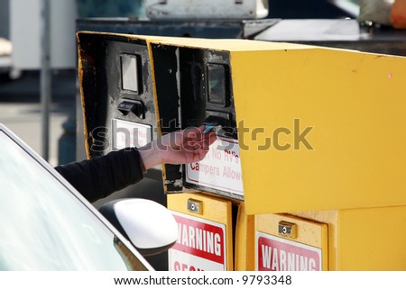 a human hand reaches for a parking ticket at a self service parking lot