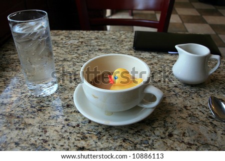 rubber duck, floats in a cup of coffee in a restaurant