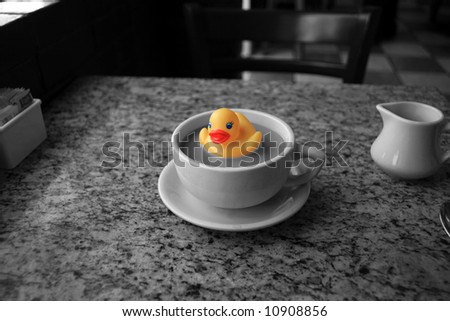 Colorized rubber duck, floats in a cup of coffee in a restaurant
