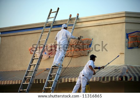 unidentifiable painters painting a building