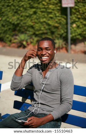 an african american male model listens to music on his personal mp3 music player
