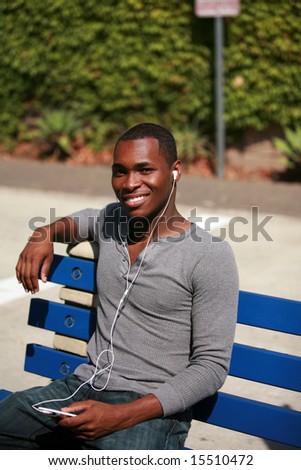 an african american male model listens to music on his personal mp3 music player