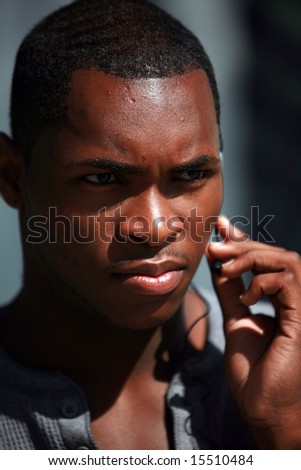 stock photo a handsome black guy talks on his hands free cellular phone 