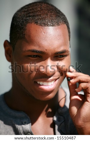 stock photo a handsome black guy talks on his hands free cellular phone