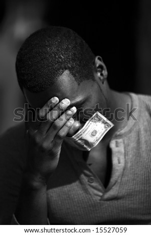 a young man wears a dollar bill taped over his mouth in protest against inflation and the rising cost of goods and services in black and white