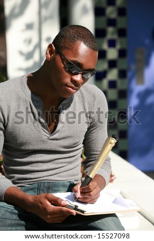 a young man takes notes on a sheet of paper with a giant pen
