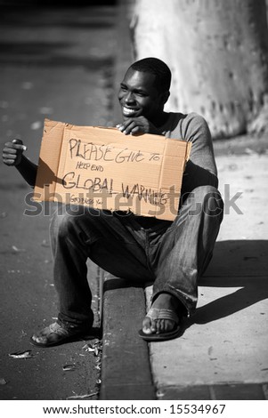 a man asks for donations to help stop Global Warming with his cardboard sign in black and white and colorized