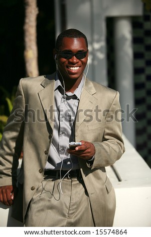 a well dressed african american Male Model listens to his personal digital music player
