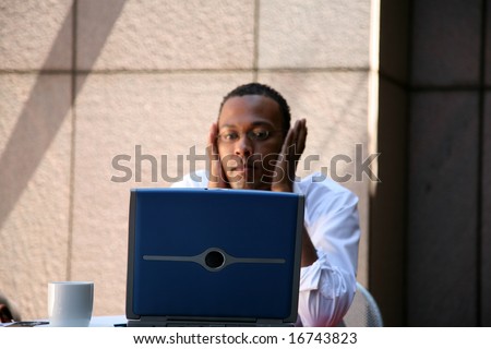 a business man works from his office at an outdoor coffee shop with his laptop and wireless internet connection