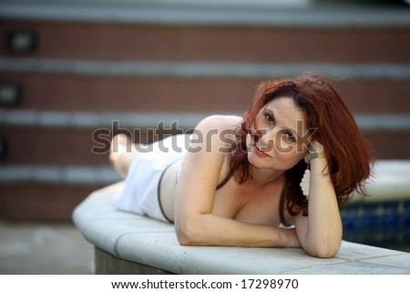 an attractive woman lounges by the pool adding that \