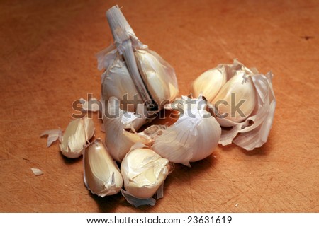 macro close-up of a crushed clove of garlic on a wooden cutting board