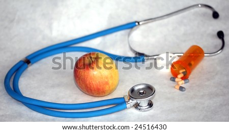 an apple with a stethascope and prescription pills represents the saying \