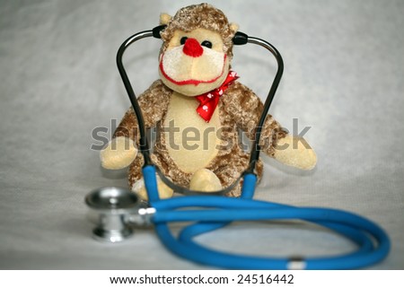 a generic stuffed toy monkey with a doctors stethoscope represents childrens doctors, pediatrics and fun check ups