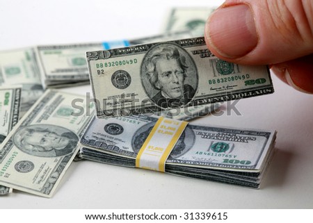 stock-photo-a-hand-holds-miniature-money-representing-the-world-financial-crisis-31339615.jpg