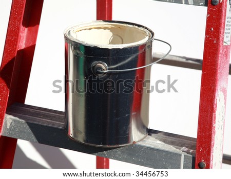 a paint bucket with paint on a ladder