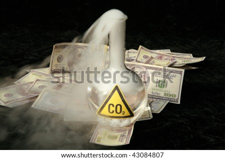 a 500ml beaker filled with CO2 infront of a pile of money, representing the business interest behind the Global Warming scare